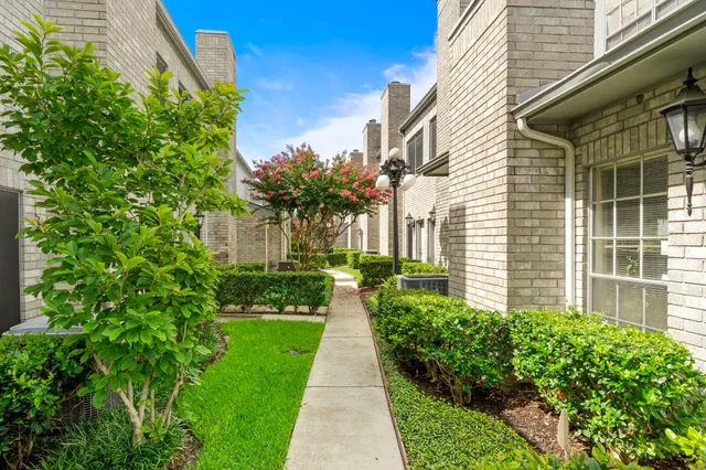 a front view of a house with a yard and potted plants