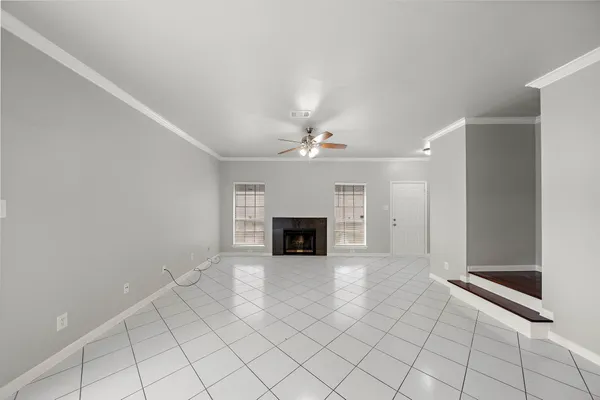 an empty room with windows and fireplace