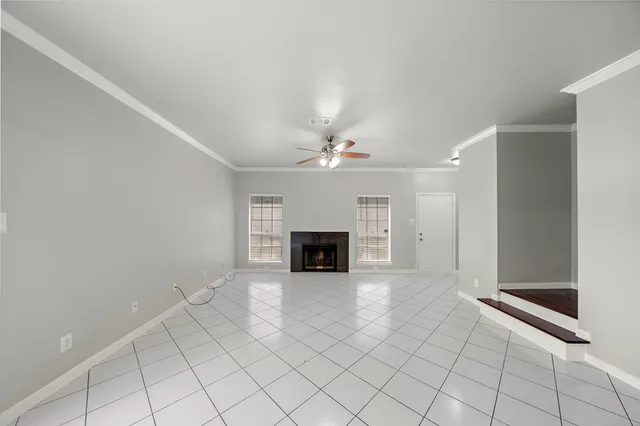 an empty room with windows and fireplace