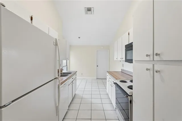 a kitchen with stainless steel appliances white cabinets and a fireplace