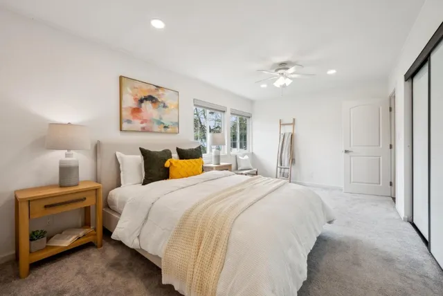 a spacious bedroom with a bed and a painting on the wall