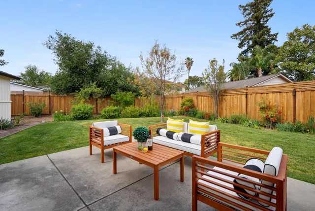 a backyard of a house with a table and chairs