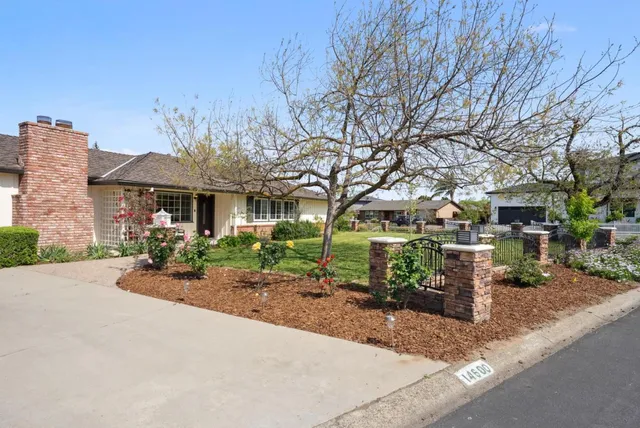 a front view of a house with garden and plants