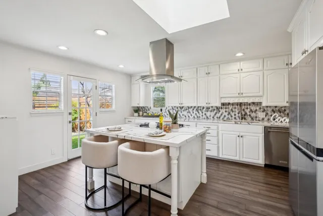 a kitchen with sink a stove and chairs