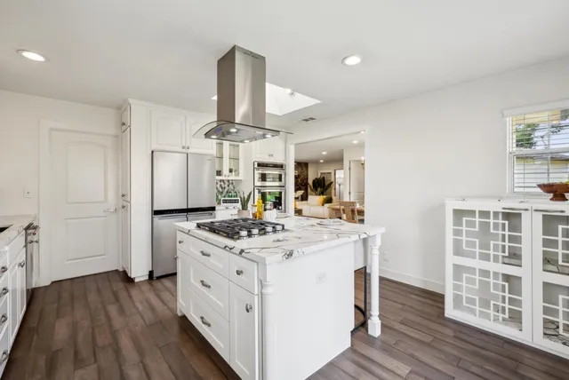 a kitchen with a stove and wooden floor