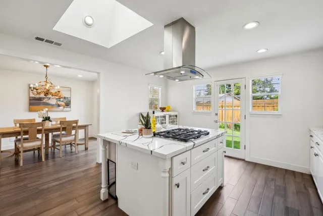 a kitchen with stainless steel appliances a stove a table and chairs in it
