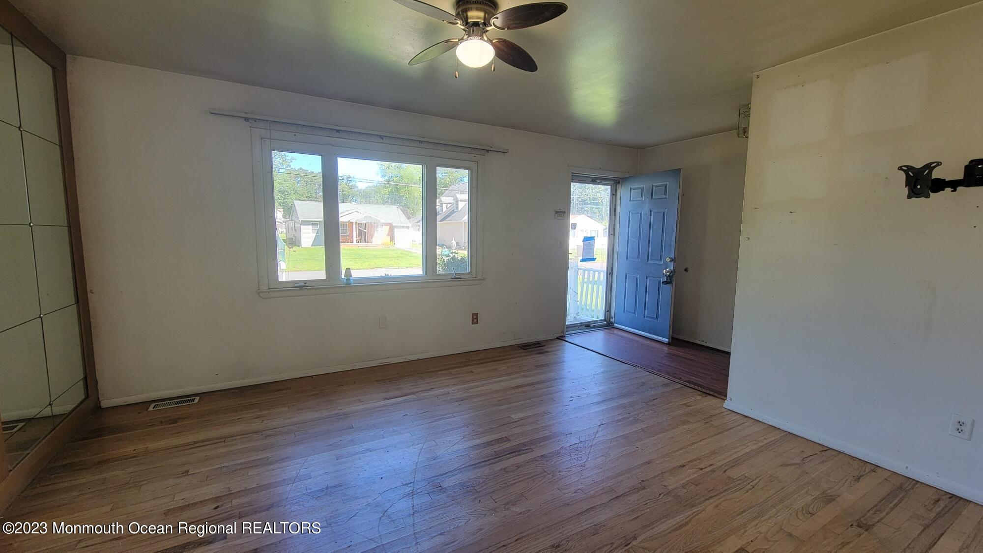 77 Smith Street Howell, NJ 07731 - Photo 4 of 15 an empty room with wooden floor and windows