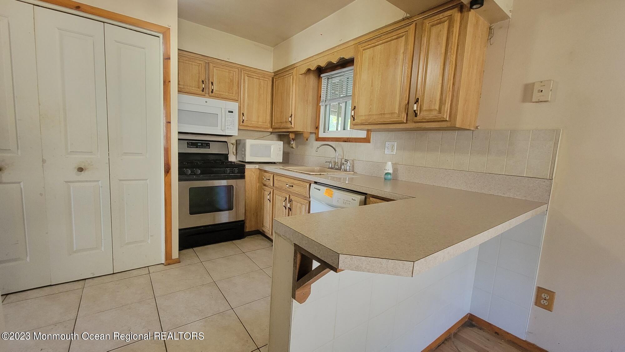 77 Smith Street Howell, NJ 07731 - Photo 7 of 15 a kitchen with stainless steel appliances a stove a sink and a refrigerator