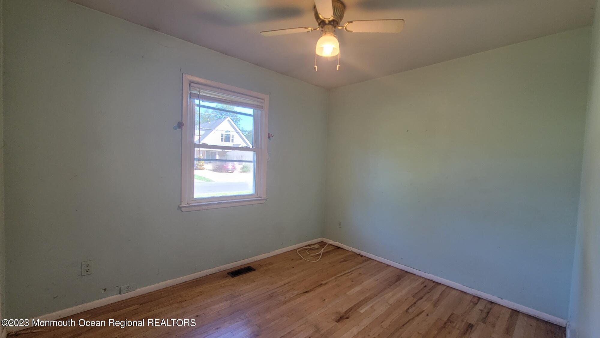 77 Smith Street Howell, NJ 07731 - Photo 9 of 15 a view of empty room with wooden floor and fan