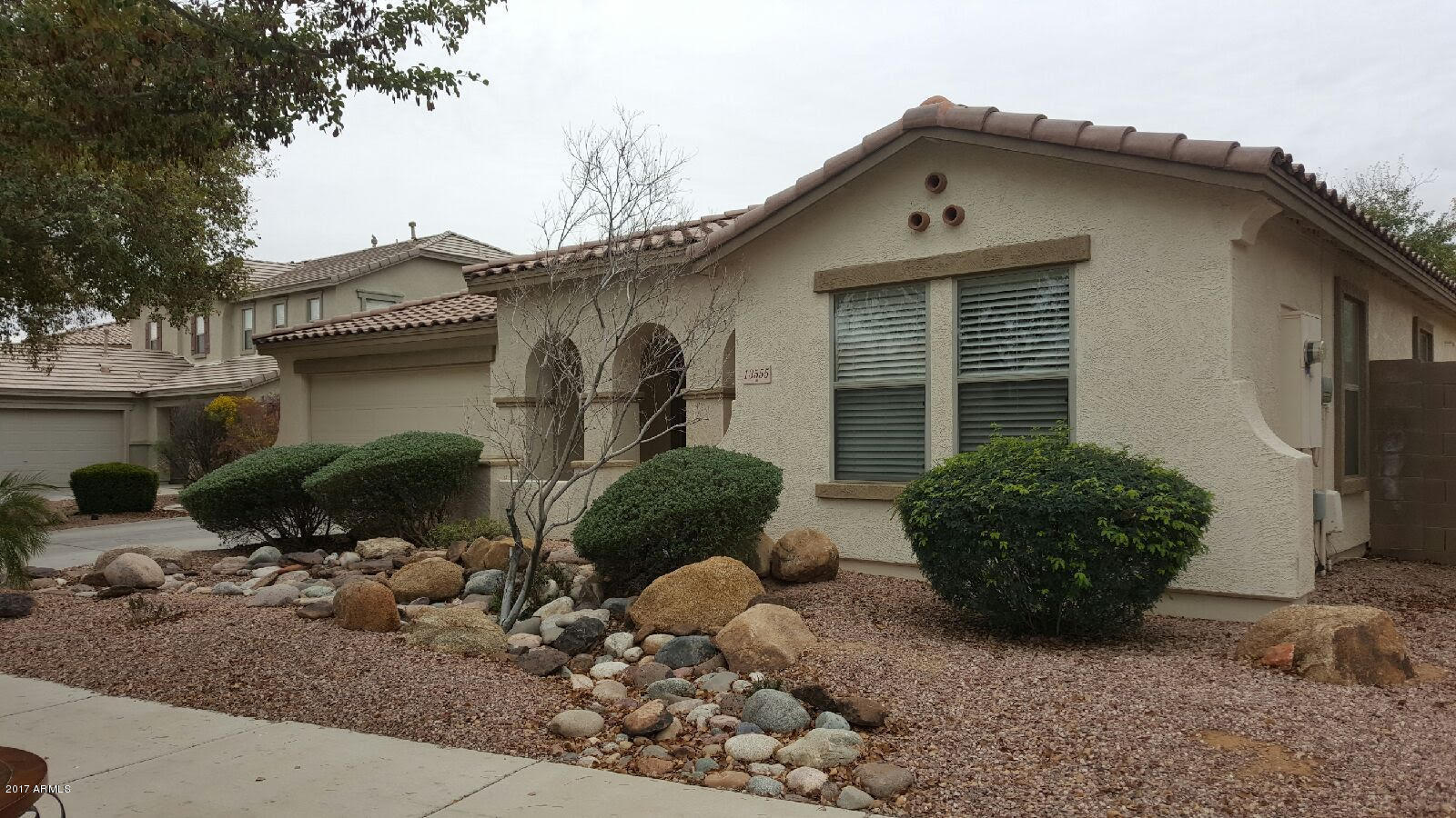 a front view of a house with a yard and potted plants