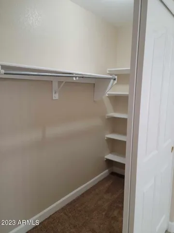 an empty room with windows and ceiling fan