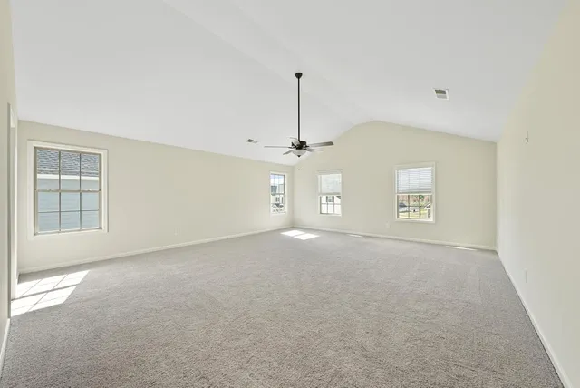 en empty room with windows and ceiling fan