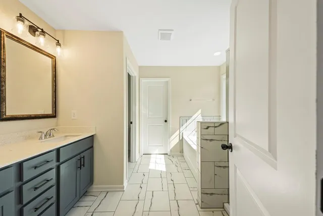 a spacious bathroom with a double vanity sink and a mirror