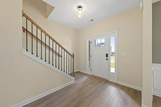 a view of a hallway with entryway with wooden floor