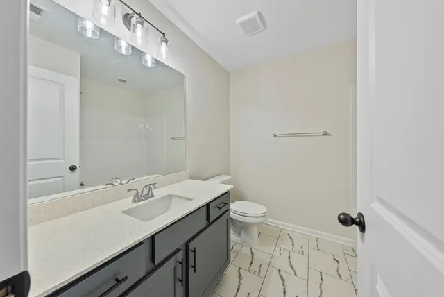 a bathroom with a sink a toilet a shower and a mirror