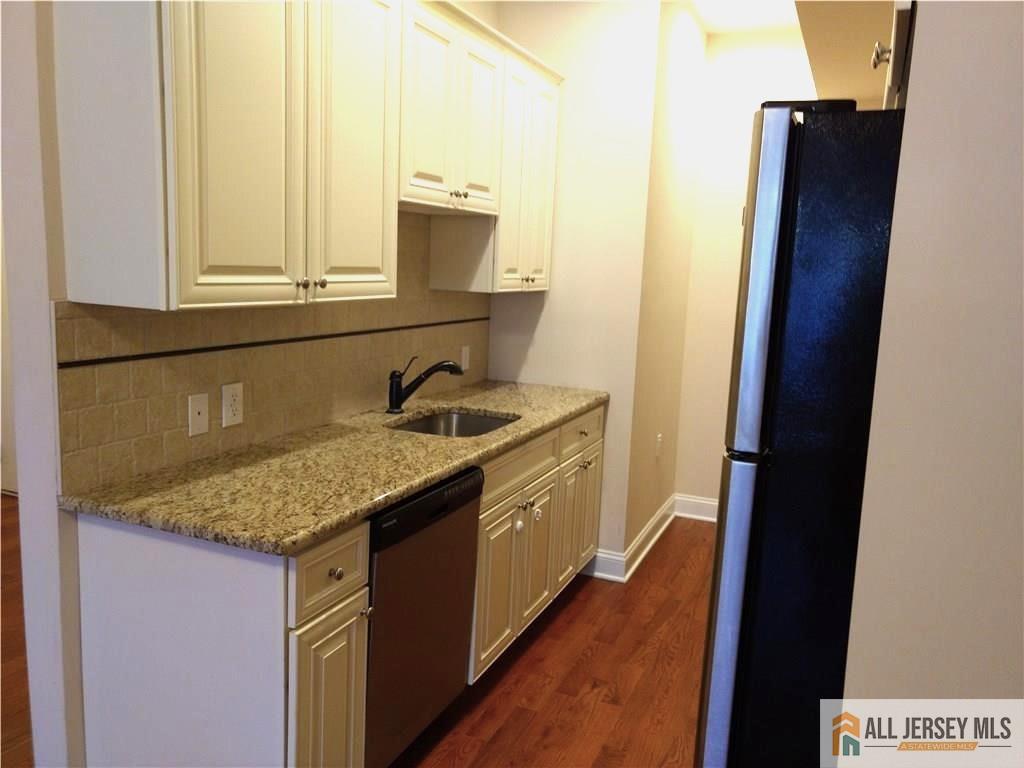 459 Main Street, Unit 1 Metuchen, NJ 08840 - Photo 12 of 21 a kitchen with a sink stove and mirror