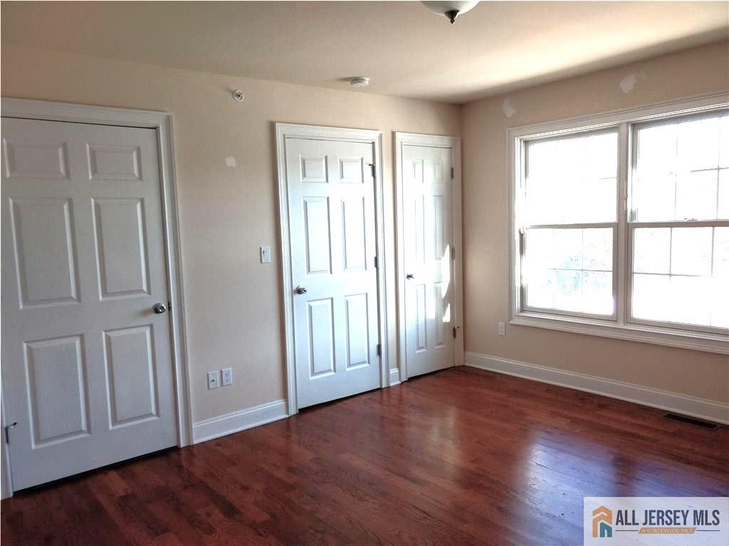 459 Main Street, Unit 1 Metuchen, NJ 08840 - Photo 14 of 21 an empty room with wooden floor and windows