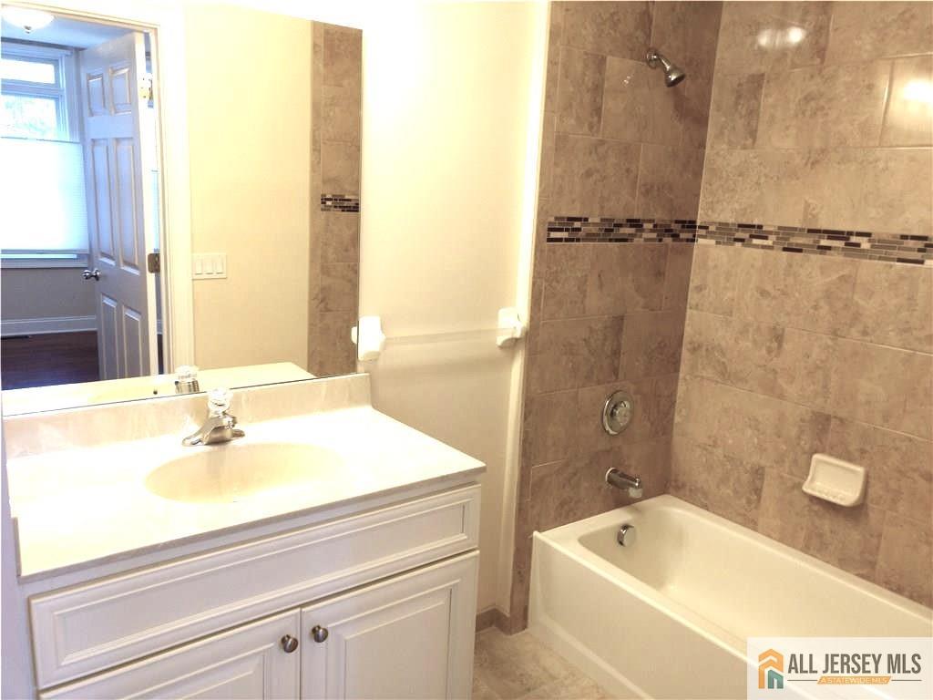 459 Main Street, Unit 1 Metuchen, NJ 08840 - Photo 17 of 21 a bathroom with a tub a sink and a window