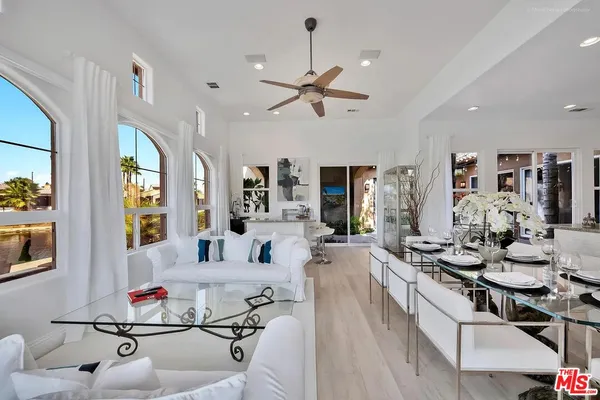 a living room with furniture kitchen view and a large window
