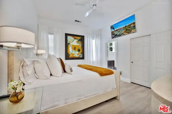 a bedroom with a large bed and a chandelier