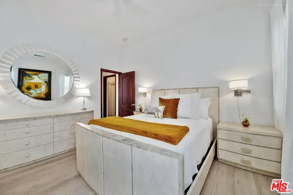 a spacious bedroom with a bed and a chandelier