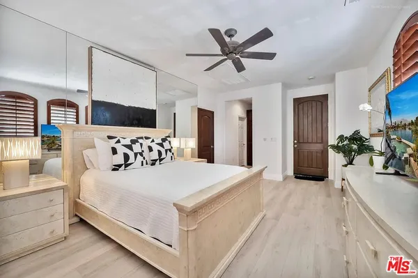 a bedroom with a large bed and a painting on the wall