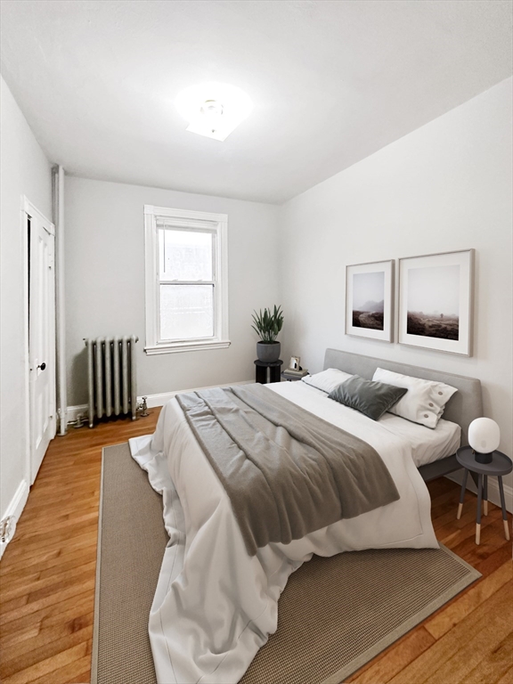 15-17 Pond Street, Unit 173 Boston, MA 02130 - Photo 5 of 9 a bedroom with a bed and wooden floor