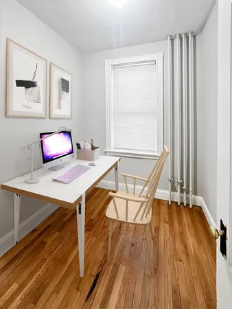 a view of a workspace with furniture and wooden floor