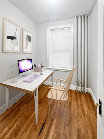 a view of a workspace with furniture and wooden floor