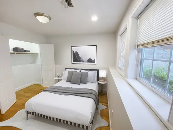 a bedroom with a bed and a large window