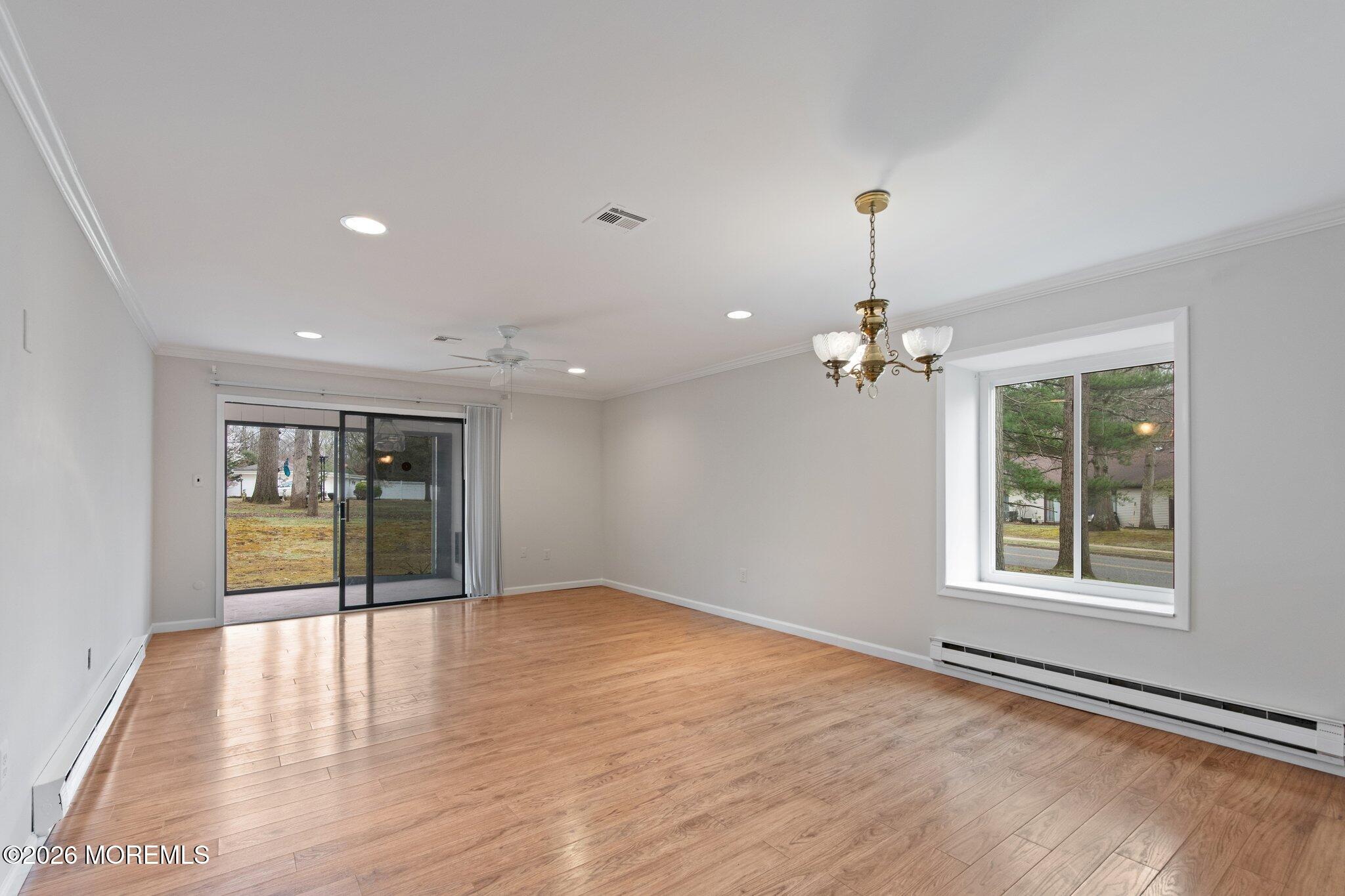102 Arrowood Road, Unit B Manalapan, NJ 07726 - Photo 19 of 41 an empty room with wooden floor and windows
