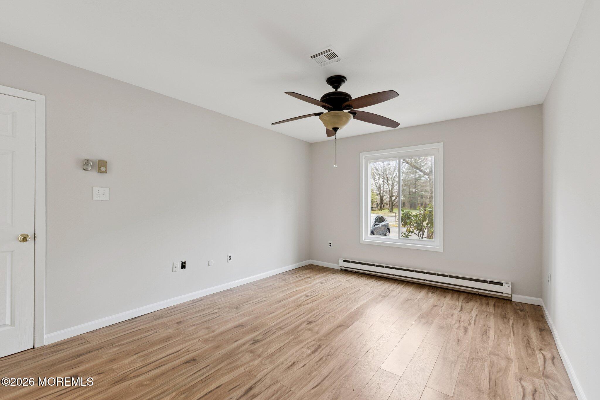 102 Arrowood Road, Unit B Manalapan, NJ 07726 - Photo 24 of 41 an empty room with wooden floor and windows