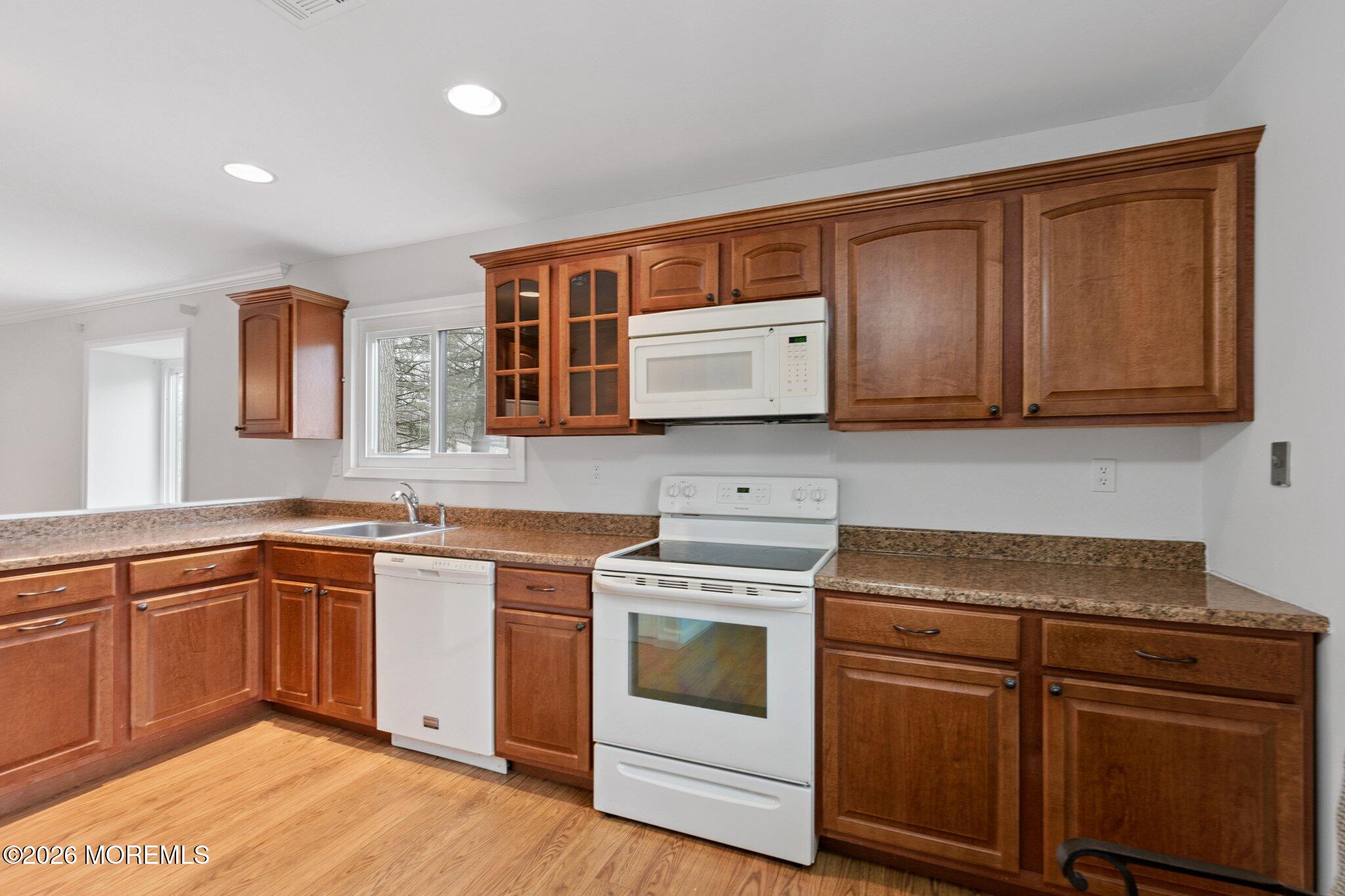102 Arrowood Road, Unit B Manalapan, NJ 07726 - Photo 9 of 41 a kitchen with stainless steel appliances granite countertop a sink and cabinets with wooden floors