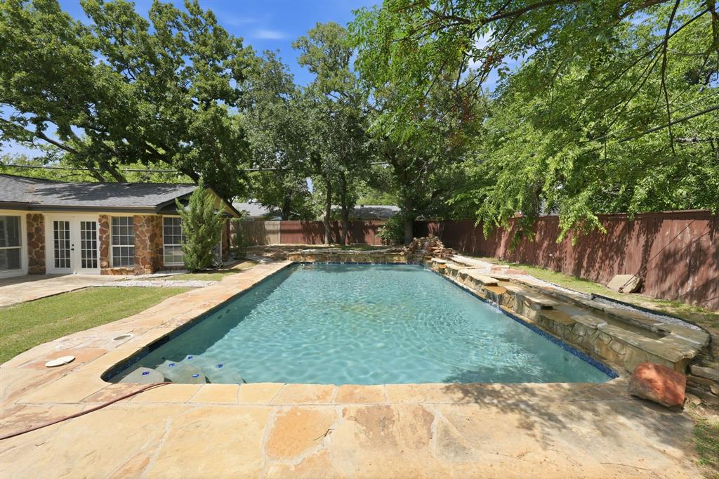 1108 Billie Ruth Lane Hurst, TX 76053 - Photo 3 of 27 Expansive in-ground pool featuring a stone surround and waterfall feature