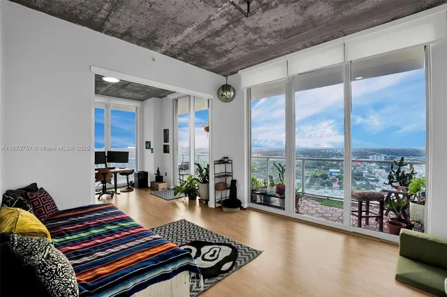a living room with furniture and a floor to ceiling window