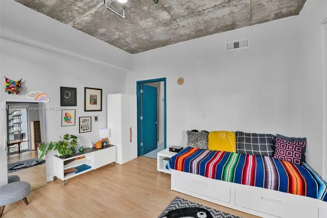 a living room with a bed and paintings on the wall