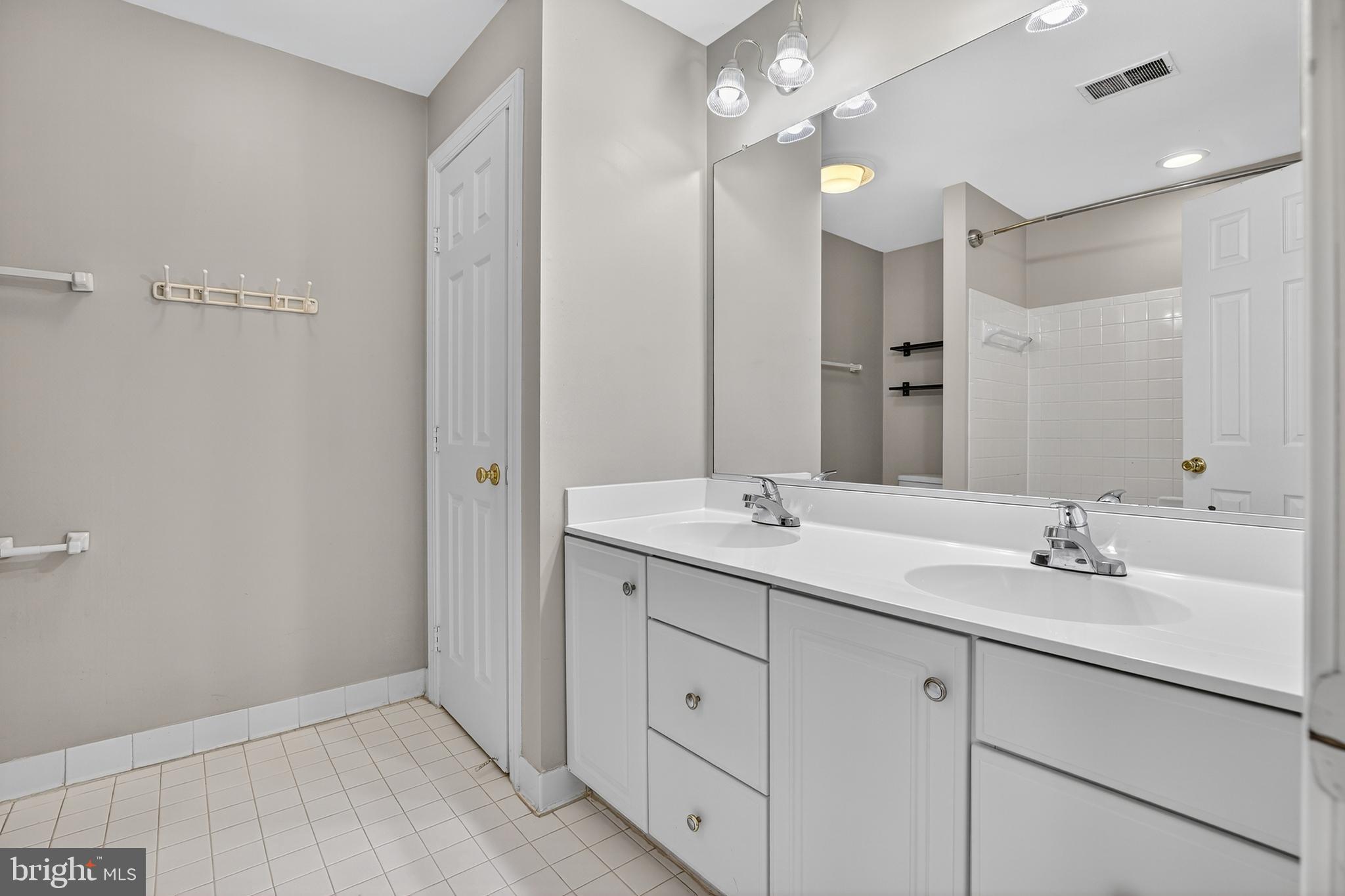 6319 Powder Flask Court Centreville, VA 20121 - Photo 27 of 31 a bathroom with a double vanity sink and mirror with shower