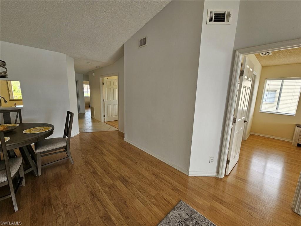 7766 Emerald Circle, Unit R201 Naples, FL 34109 - Photo 11 of 35 a view of a livingroom with furniture and wooden floor