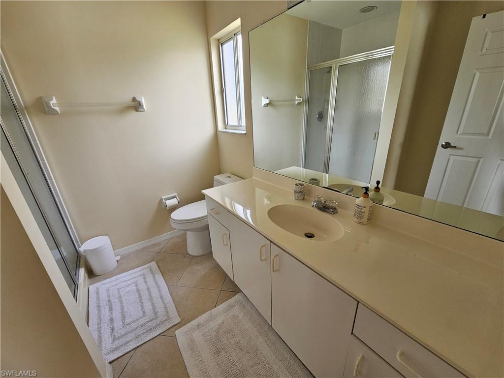 7766 Emerald Circle, Unit R201 Naples, FL 34109 - Photo 13 of 35 a bathroom with a sink a mirror and a toilet