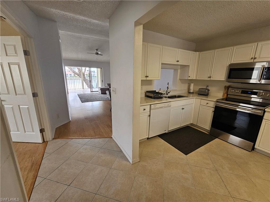 7766 Emerald Circle, Unit R201 Naples, FL 34109 - Photo 17 of 35 a kitchen with stainless steel appliances granite countertop a stove a sink and a refrigerator