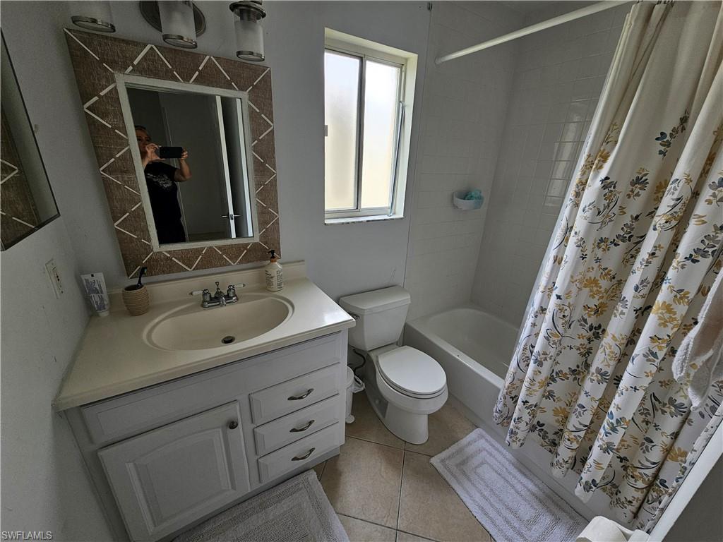 7766 Emerald Circle, Unit R201 Naples, FL 34109 - Photo 21 of 35 a bathroom with a granite countertop sink toilet and shower