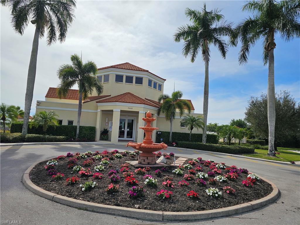 7766 Emerald Circle, Unit R201 Naples, FL 34109 - Photo 24 of 35 a front view of a house with a garden and trees