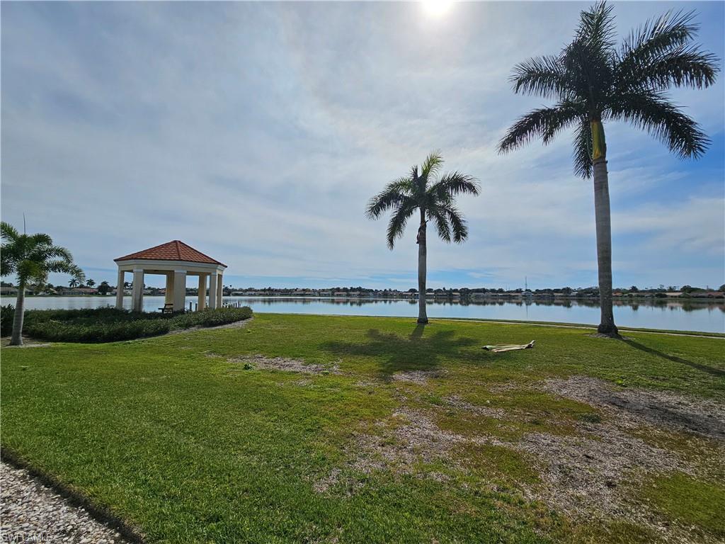 7766 Emerald Circle, Unit R201 Naples, FL 34109 - Photo 29 of 35 a view of a swimming pool with a yard and palm trees