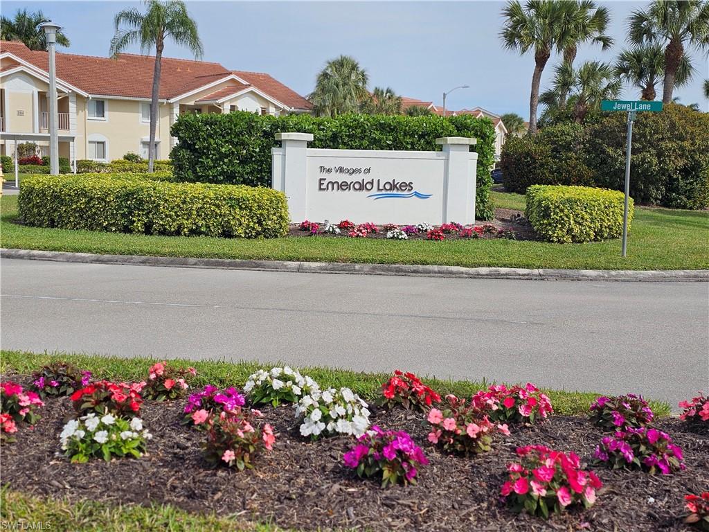 7766 Emerald Circle, Unit R201 Naples, FL 34109 - Photo 31 of 35 a sign that is in front of flowers