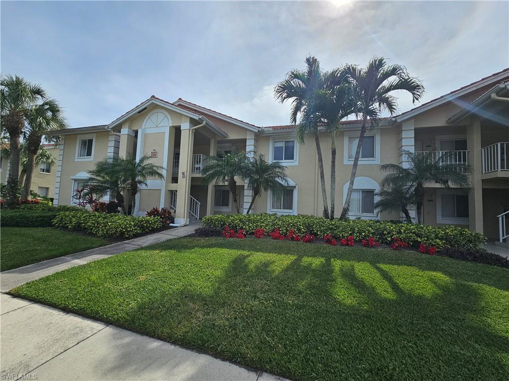 7766 Emerald Circle, Unit R201 Naples, FL 34109 - Photo 34 of 35 a front view of house with yard and green space