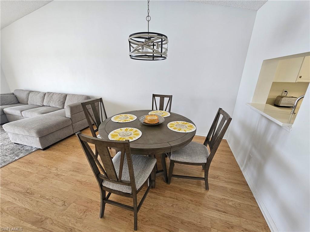 7766 Emerald Circle, Unit R201 Naples, FL 34109 - Photo 8 of 35 a view of a dining room with furniture and wooden floor