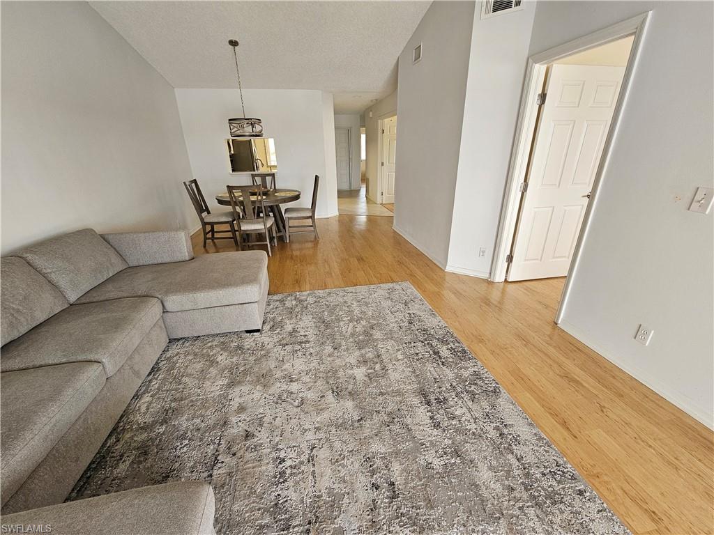 7766 Emerald Circle, Unit R201 Naples, FL 34109 - Photo 9 of 35 a living room with furniture and a wooden floor