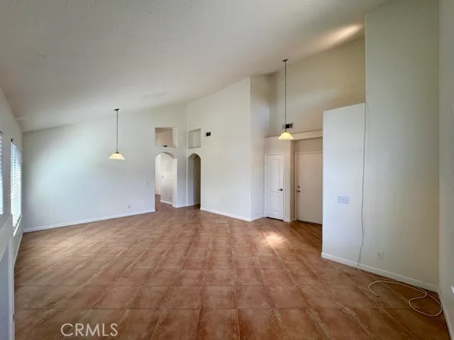 a view of a big room with wooden floor and windows