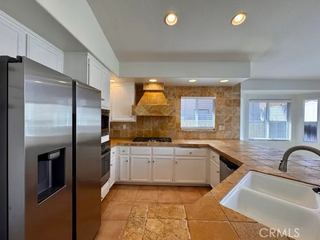 a kitchen with stainless steel appliances granite countertop a sink and a refrigerator
