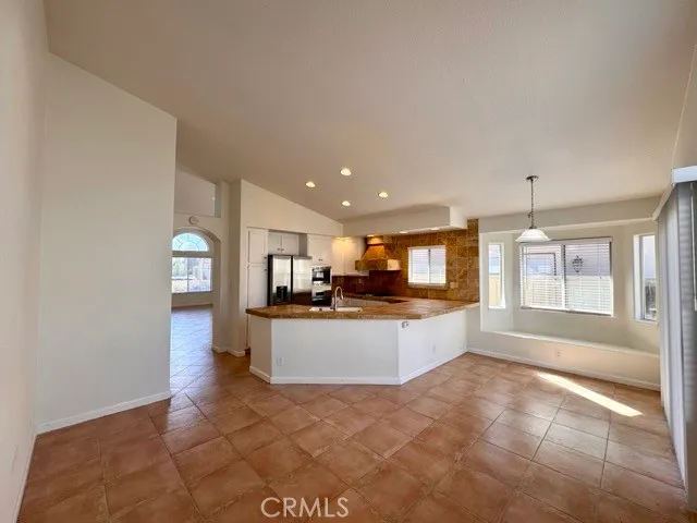 a large kitchen with kitchen island a sink a counter space and a window